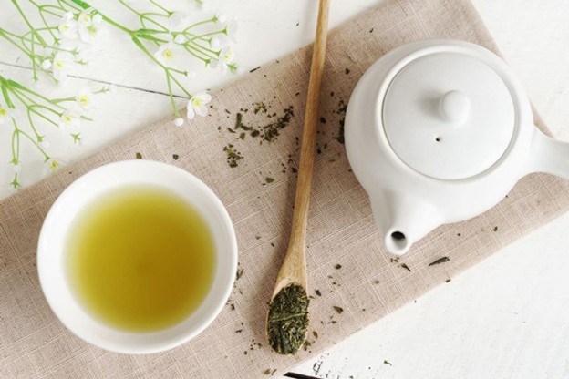 A teapot and a cup of green tea
Description automatically generated