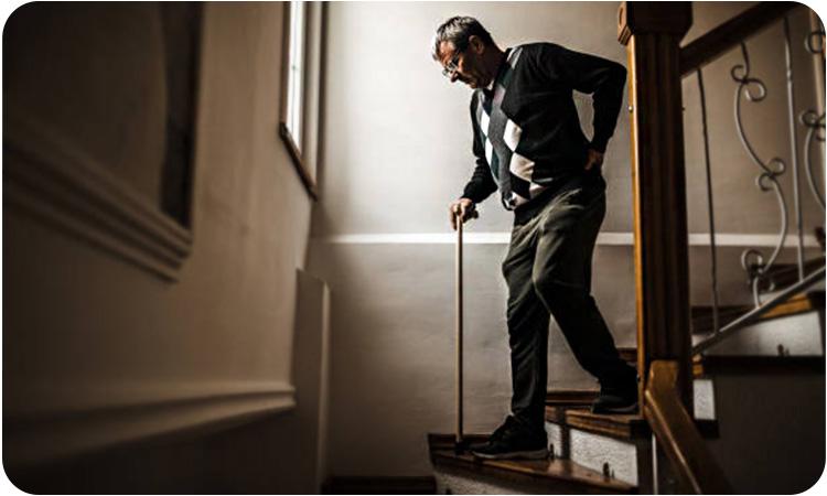 تصویری از فردی که حین پایین آمدن از پله درد کمر دارد.